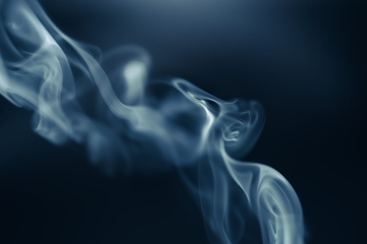 Intriguing capture of swirling smoke against a dark background, creating a mysterious and ethereal atmosphere.